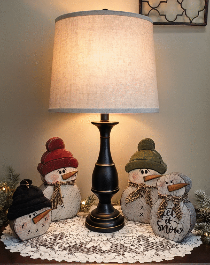 Handcrafted Amish wooden snowmen indoor Christmas decor arranged on a table under a lamp