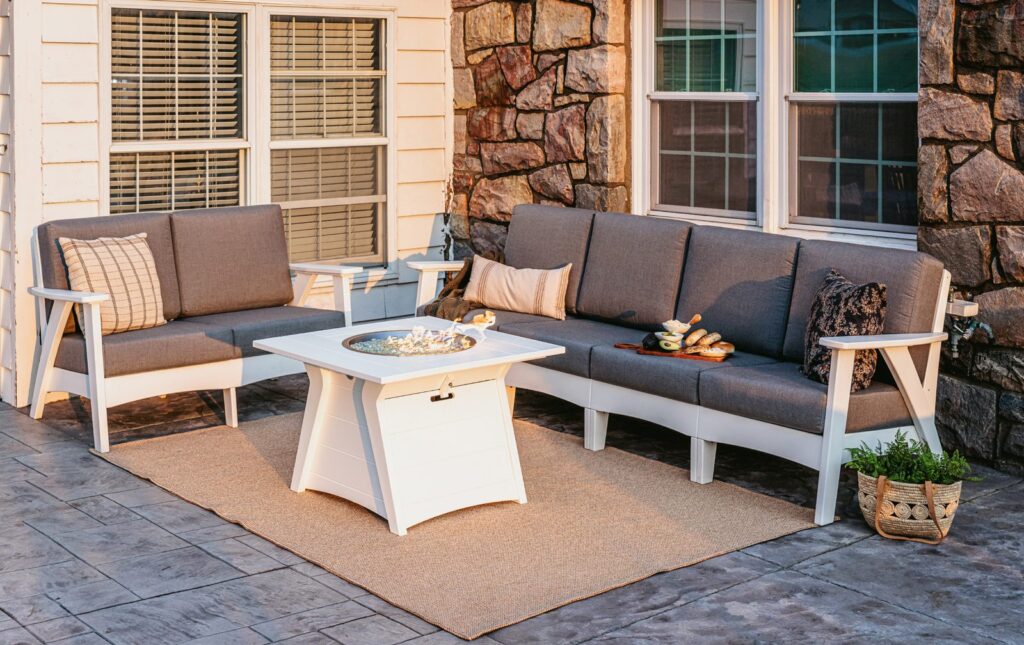 Regency poly deep seating sectional with Sunbrella cushions and a fire table